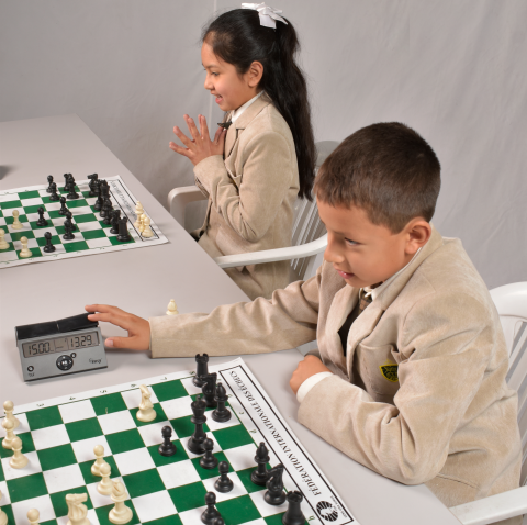 Los estudiantes atienden y escuchan los fundamentos del ajedrez.